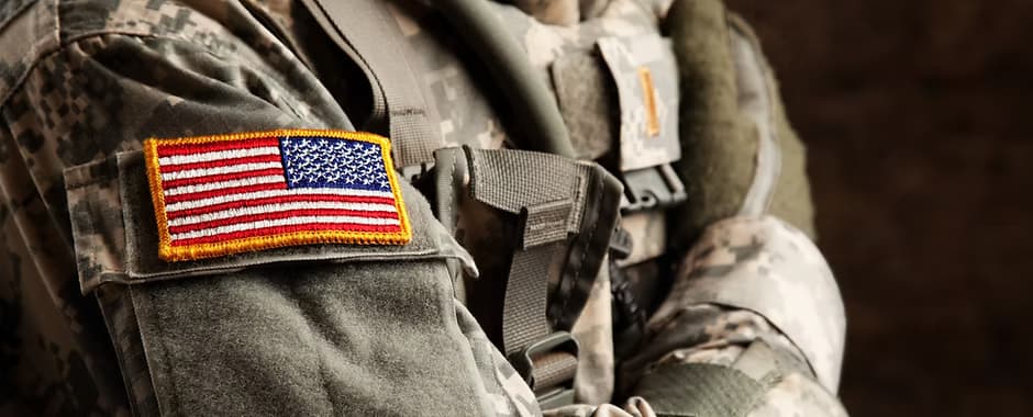 A United States flag patch on the sleeve of a soldier's camouflage uniform